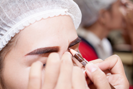 eye,Asia woman applying permanent make up on eyebrows tattoo.の写真素材