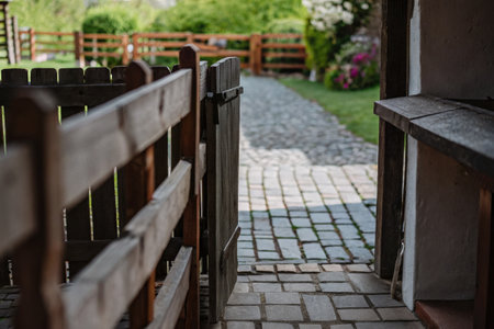 Cozy fenced pathway leading to a green gardenの素材