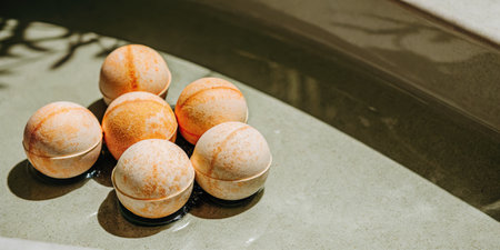 Fresh bath bombs on a marble countertop in natural lightingの素材