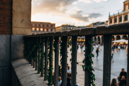 Historic stone balcony with intricate railing overlooking a plazaの素材