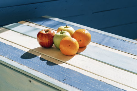 Apples and Oranges on Blue and White Painted Wooden Table Outdoorsの素材