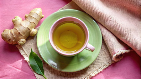 Cup of green tea with ginger on pink background, top viewの素材