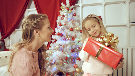 Mother gives a New Year gift to her little cute daughterの写真素材