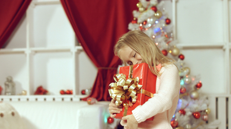 Cute girl jumping from happiness getting gift for the new yearの写真素材