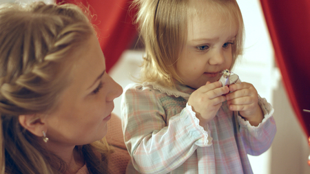 Mother with adorable daughter near the Christmas treeの写真素材