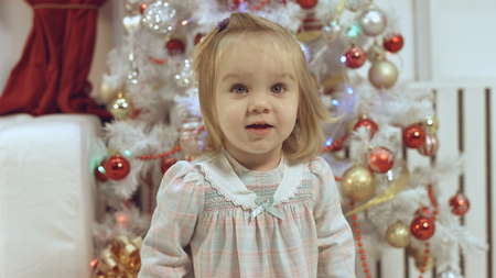 Cute little girl near the decorated Christmas treeの写真素材