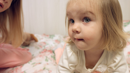 Cute little girls on the couch with floral printの写真素材