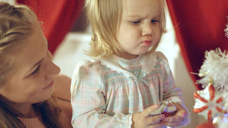 Mother with adorable daughter near Christmas treeの写真素材