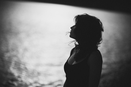 Silhouette of the young woman in dress on the beachの写真素材