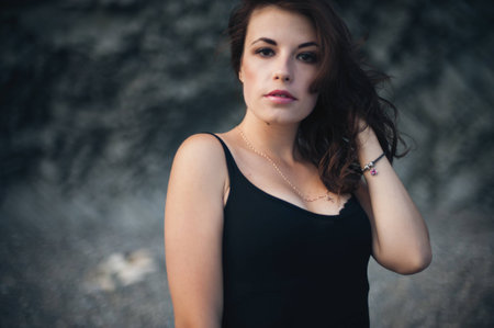 Portrait of the beautiful girl in the black dress outdoorsの写真素材