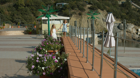 Mother with little daughter walking in the park by the seaの写真素材