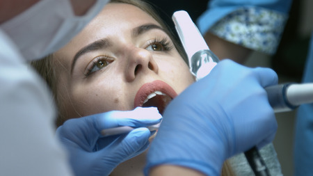 Beautiful girl on the examination by the doctor dentistの写真素材