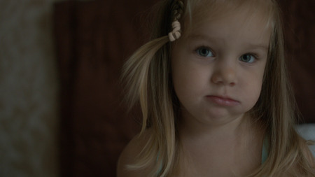 Cute little girl sitting on the couchの写真素材