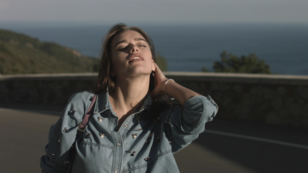 Happy and free girl walking on the road and smilingの写真素材