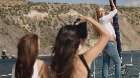 Beautiful girls with camera on the yachtの写真素材