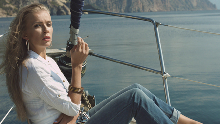 Blonde girl smokes on the yachtの写真素材