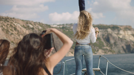 Young beautiful girls making photo on the yacht