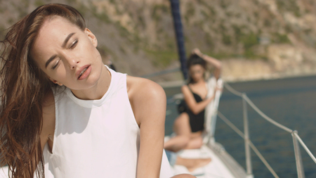Young beautiful brunette girl sitting on the yachtの写真素材