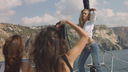 Young girls making picture on the yachtの写真素材