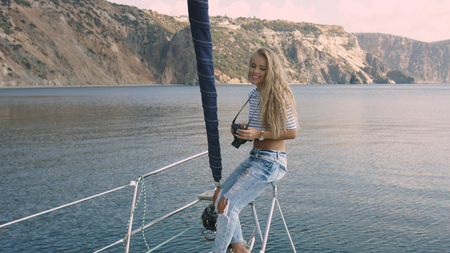 Young woman taking photo of beautiful sea lagoonの写真素材