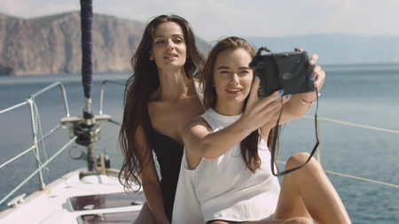 Best friends using camera and taking selfie on luxury sailing boat selfieの写真素材