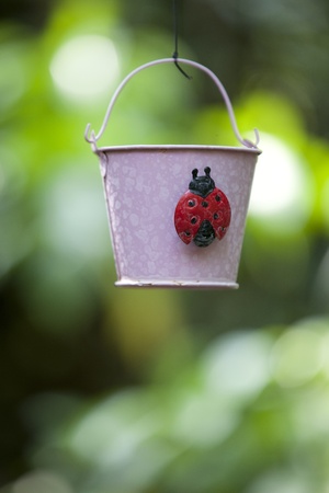 A Hanging Pink Pail with a cute Ladybug.の写真素材