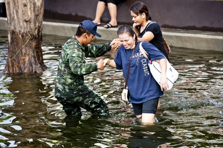 Bangkok, Thailand - November 5, 2011: The Soldier help two people for travel.