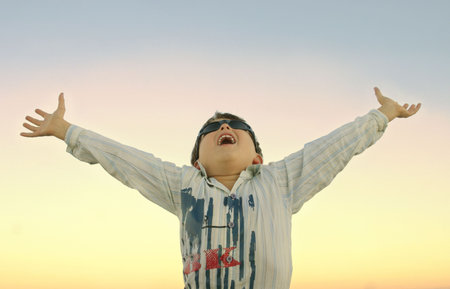 Energise your soul - Boy with raised arms at one with nature/god.の写真素材