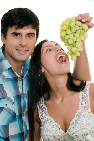 Adult couple playfully eating grapesの写真素材