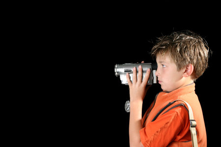 Boy filming using a home video camera, camcorder. Space for text.の写真素材