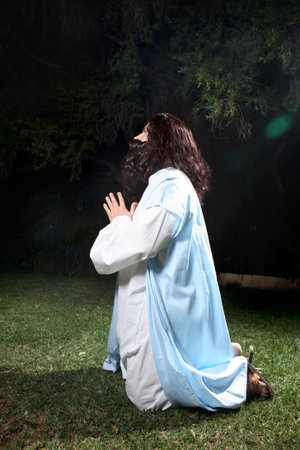 Side view of Jesus in Garden of Gethsemane on knees praying to God.  の写真素材