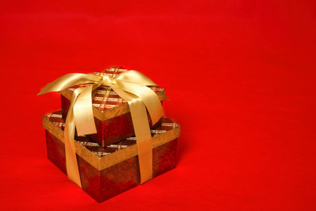 Gift boxes tied up with gold satin ribbon for Christmas, a birthday or other special occasionの写真素材