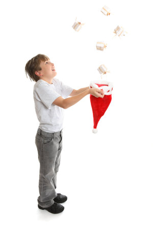 Gifts galore.   An excited  full length boy catches Christmas presents falling from above.の写真素材