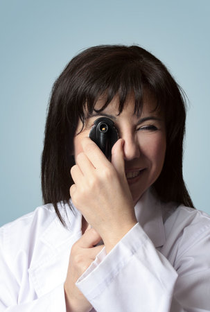 A female optician turning the wheel dial of an opthalmoscope. closeup.の写真素材