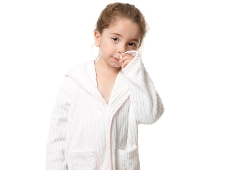 Pretty young girl standing in a white with pink trim bathrobeの写真素材