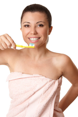 Smiling woman holding a toothbrush with toothpaste about to brush her teeth.の写真素材