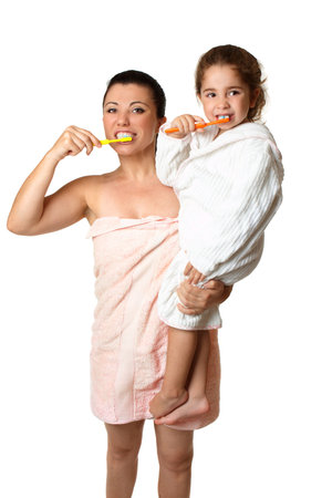A mother and  her young daughter brushing their teeth .の写真素材