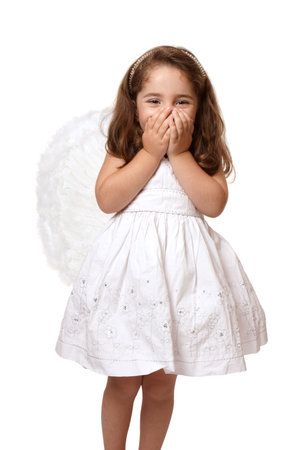 Little angel or fairy girl giggling with two hands covering her mouthの写真素材