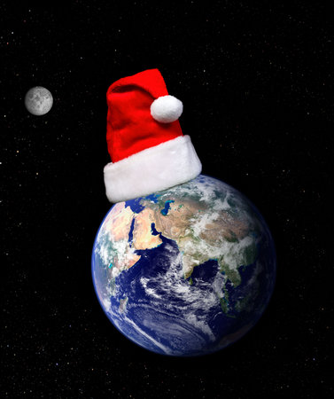 Earth globe and santa hat on a dark background with moon and twinkling stars. Concept, Christmas around the world, Christmas holidays, etc    Earth globe showing Europe and Asia from Nasa terra satellite MODIS.  Space for copy.の写真素材