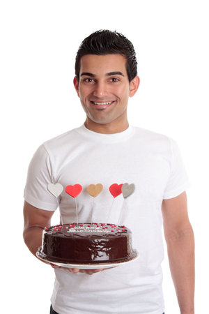 Smiling man holding a chocolate birthday cakeの写真素材