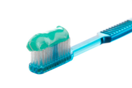 A blue toothbrush holding sparkly mint toothpaste.  Closeup with shallow dof.の写真素材