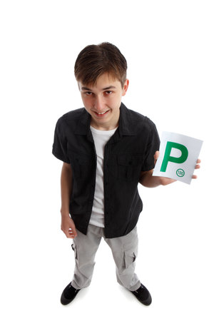 A teenager holds the green magnetic provisional  P plates for vehicle.  White background.の写真素材