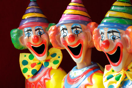 A row of sideshow carnival game clowns with mouths open.  Focus to middle clown.の写真素材