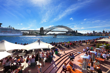 Sydney, Australia - September 15, 2013: Residents and visitors dine, relax and basque in the glorious afternoon sun quayside by the harbour Sydney Australia.  Iconic Circular Quay is a must visit for every tourist.のeditorial素材