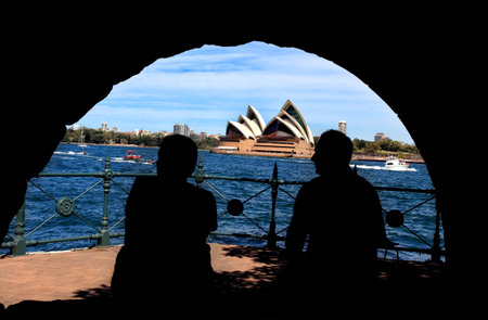 Bradfield Park, Sydney Australia - October 6, 2013   Silhouette of man and woman enjoying Sydney Harbour and Opera House views from a stone arch shelter in Bradfield Park のeditorial素材