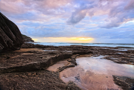 The suns rays break through the clouds at Mackenzies Bay, Australia, colouring the sky の写真素材