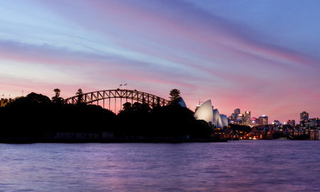 An awesome pink and red sunset sky over beautiful Sydney Harbour, Opera House, Harbour Bridge and CBD Australia   のeditorial素材