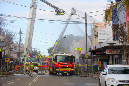 ROZELLE, AUSTRALIA - SEPTEMBER 4, 2014;   Firefighters on cranes douse the flames of a convenience...