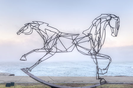 BONDI, AUSTRALIA -  OCTOBER 25, 2014; Sculpture by the Sea free public annual event 2014.  Sculpture titled Which Way Forwards by  Harrie Fasher, NSW.   A double headed horse, one side galloping, the other side in control - a look at  life  Materials, steのeditorial素材