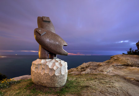 BONDI, AUSTRALIA -  OCTOBER 27, 2014; Sculpture by the Sea Annual Event 2014.  Sculpture titled Pink Granite 14 by Koichi Ogino, Japan. On the rocks at Sth Bondi.    Lightpainted with a torch front and right side at twilight dawn.  Long exposureのeditorial素材